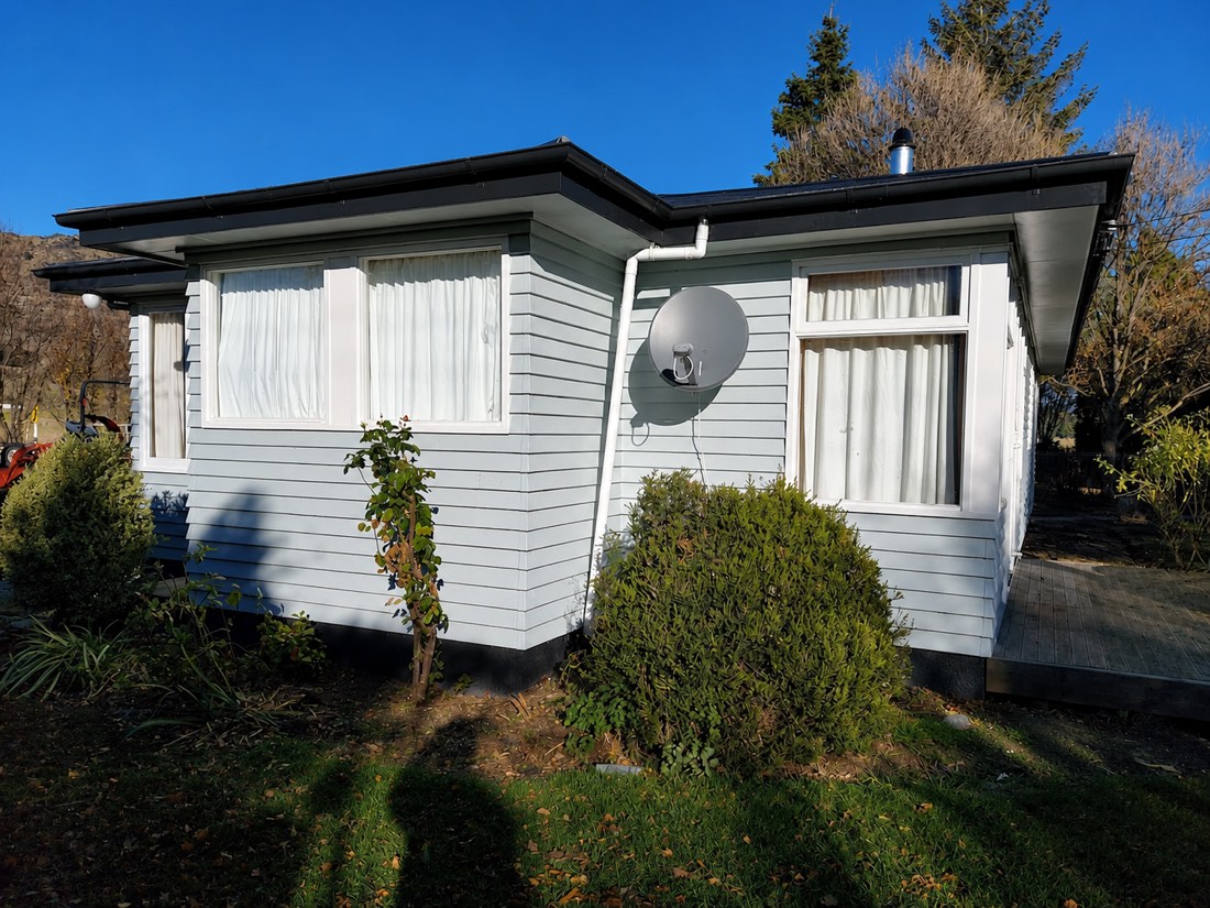 Repainted pale blue weatherboard bungalow with crisp white window trim