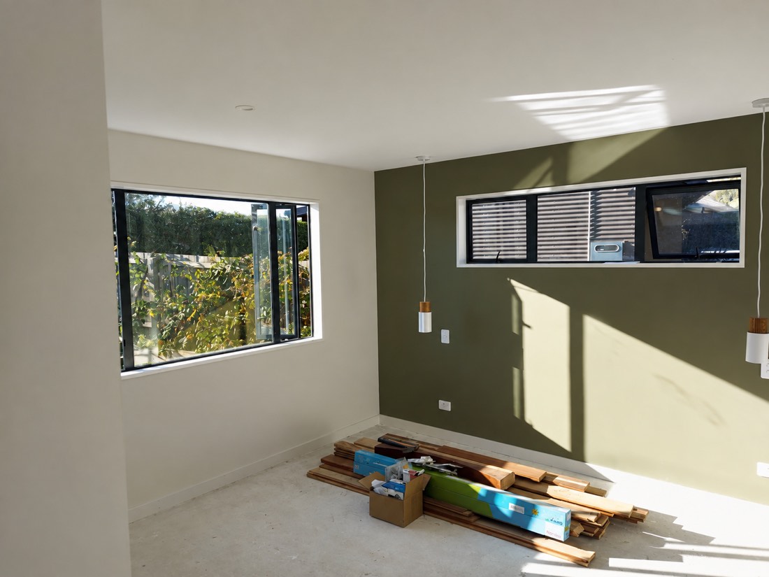 Olive feature wall mid job with timber and materials staged on the floor