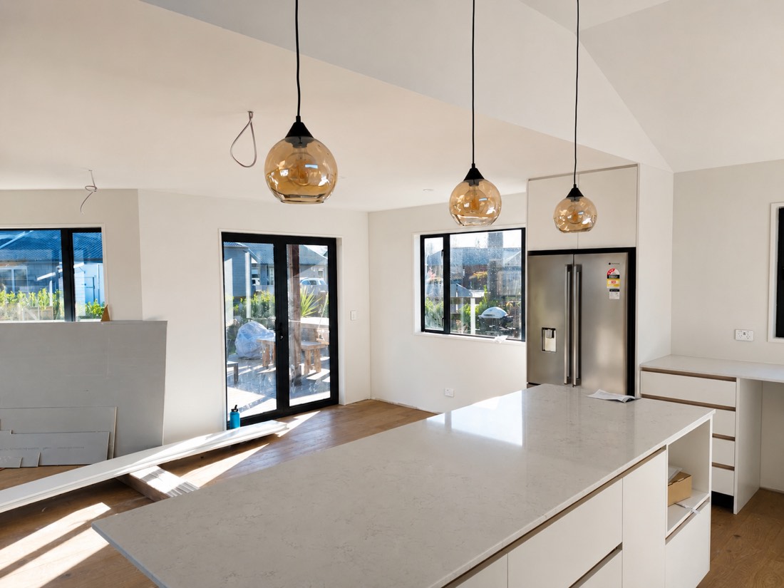 New kitchen interior painted in crisp white with amber pendant lights